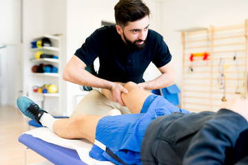 massaging knee of athlete patient