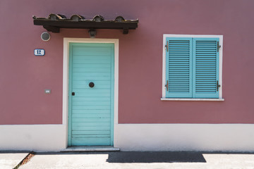 old house wall with blue wooden door and window