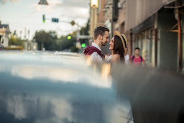 Husband and wife on a walk with a white moped in the city near the ferris wheel eating ice cream