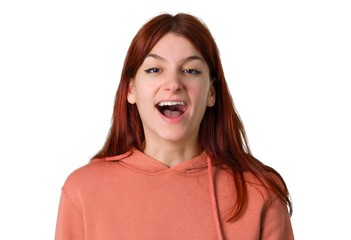 Young redhead girl with pink sweatshirt shouting to the front with mouth wide open on isolated white background