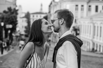 A loving couple on a walk in the city touch each other's noses