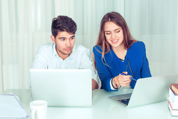 Smiling woman working with man on laptop