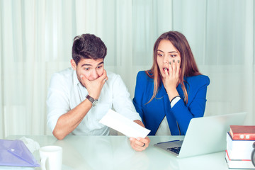 Super shocked man and woman watching papers