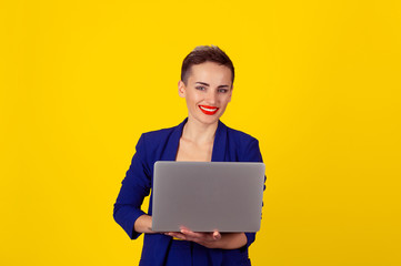 woman holding computer laptop in side view looking at camera smiling