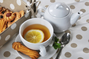various cookies and biscuits baked at home in a container and tea in a retro cup with free space for text