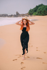 happy woman running along beach, summer evening