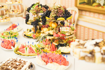 Delicious and tasty dessert table with cupcakes shots at reception closeup