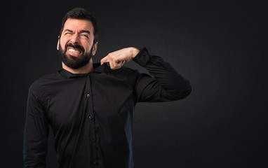 Handsome man with beard stressed overwhelmed on black background