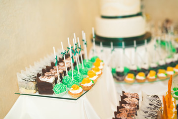 Delicious and tasty dessert table with cupcakes shots at reception closeup