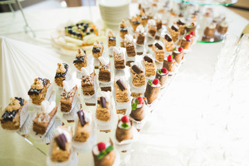 Delicious sweets on wedding candy buffet with desserts, cupcakes