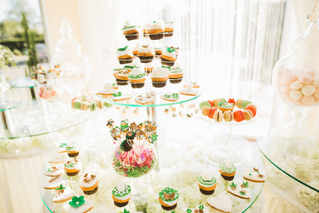Delicious sweets on wedding candy buffet with desserts, cupcakes