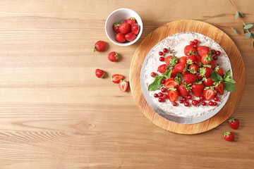 Delicious homemade cake with fresh berries on wooden table and space for text, top view