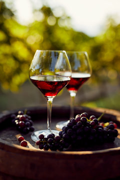 Fototapeta Two glasses of red wine on a wooden barrel