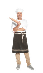 Mature male chef holding rolling pin on white background