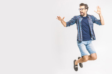 Happy excited cheerful young man jumping and celebrating success isolated on a white background