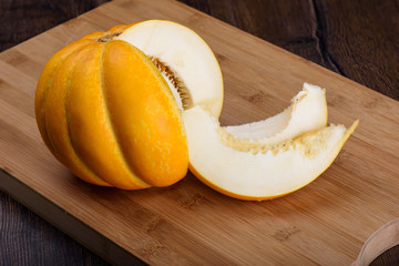 Melon and slices of melon on a wooden cutting board