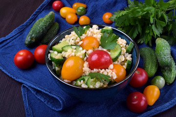 Tabbouleh salad with bulgur, cucumbers and tomatoes. Middle Eastern cuisine meal