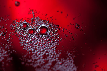 Detail of a glass with red wine and bubbles