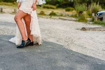 Fototapeta na wymiar Woman dressed as a bride with men's shoes