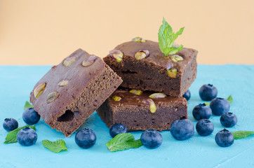 Brownie with blueberries on blue background.