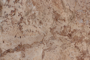Brown structure with fractures and different spots. Classic travertine texture.