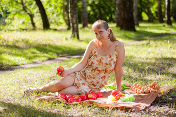 The Russian woman has a rest on a picnic in the wood in the summer