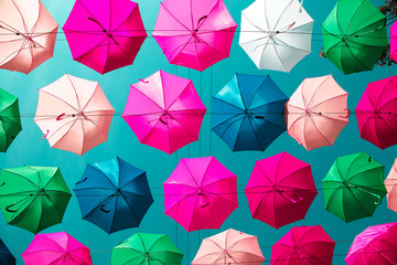 Multicolored floating umbrellas against the blue sky.