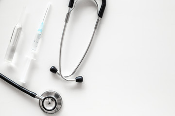 Infuenza vaccine in syringe near stethoscope on white background top view copy space