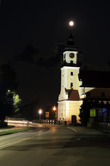 Kościół w nocy, ksjężyc w pełni nad wieżą kościoła.