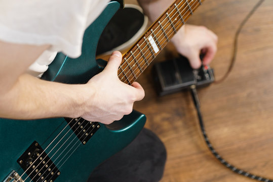 Man adjusting guitar effects pedal