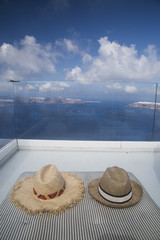 Straw hats on a sun bed with an amazing view of caldera in Santorini,Greece 