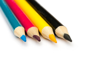 Four colored pencils. The colors cyan, magenta, yellow and black. The concept of polygraphy.