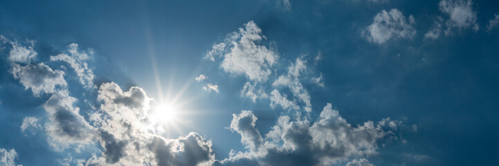 Naklejka na ściany i meble Beautiful blue sky panorama, sunrays through the clouds