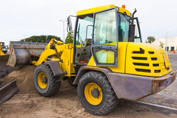 Front end loader dumping stone and sand at at constraction site