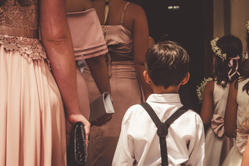 Cute ring bearer and the bridemaids preparing to enter to the church.