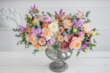 Wall murals Gorgeous bouquet of different flowers. floral arrangement in vintage metal vase. table setting. lilac and peach color
