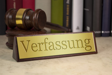 A gavel and nameplate with engraving Constitution