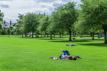 Couple relaxing in Sheep's Green park, Cambridge, England, 21st of May 2017