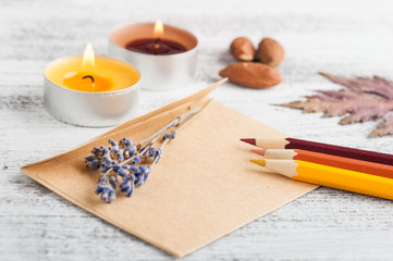 Craft envelope and pencils, lit candles