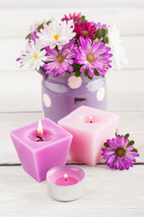 Purple lit candles and pink garden flowers