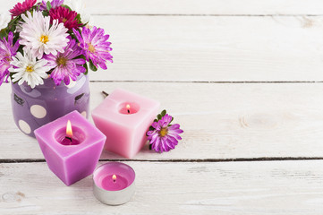 Purple lit candles and pink garden flowers