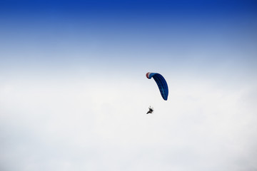 Guy flying on the coloful sky by paramotor kite,extreme activity port. feel freedom like birds. concept overcome the limits of human physiology.