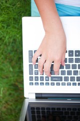 Fototapeta na wymiar Closeup of a Young Woman Typing on a Laptop