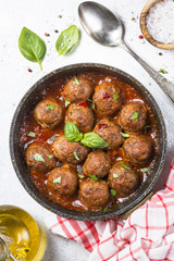 Meatballs in tomato sauce on white table.