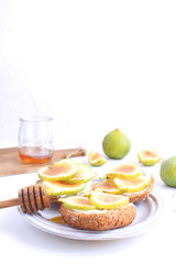Fresh green figs Porcelain plate Wholegrain bread Honey Goat cheese Healthy eating concept Canapes Sandwiches Appetizer Copy space White background Vertical