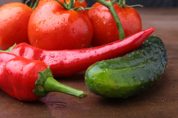 composition with chili pepper, cucumber and tomato close up