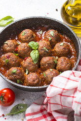 Meatballs in tomato sauce on white table.
