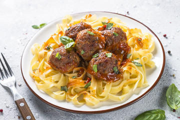 Meatballs in tomato sauce with pasta tagliatelle top view.