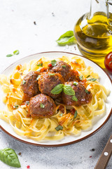 Meatballs in tomato sauce with pasta tagliatelle top view.