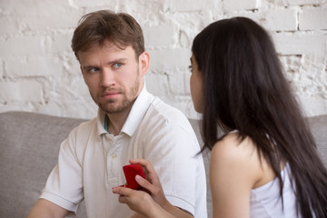 Decisive girlfriend making marriage proposal to frustrated boyfriend, presenting engagement ring,...